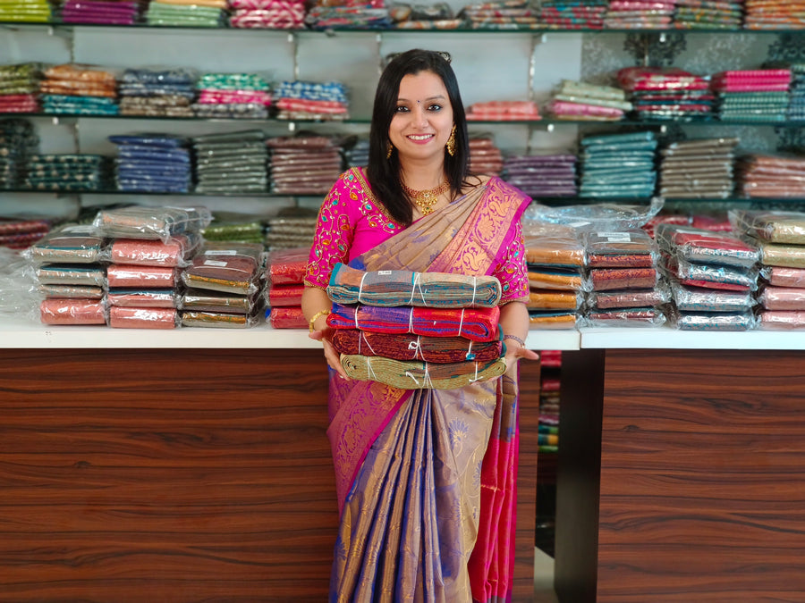 A saree seller behind her shop counter